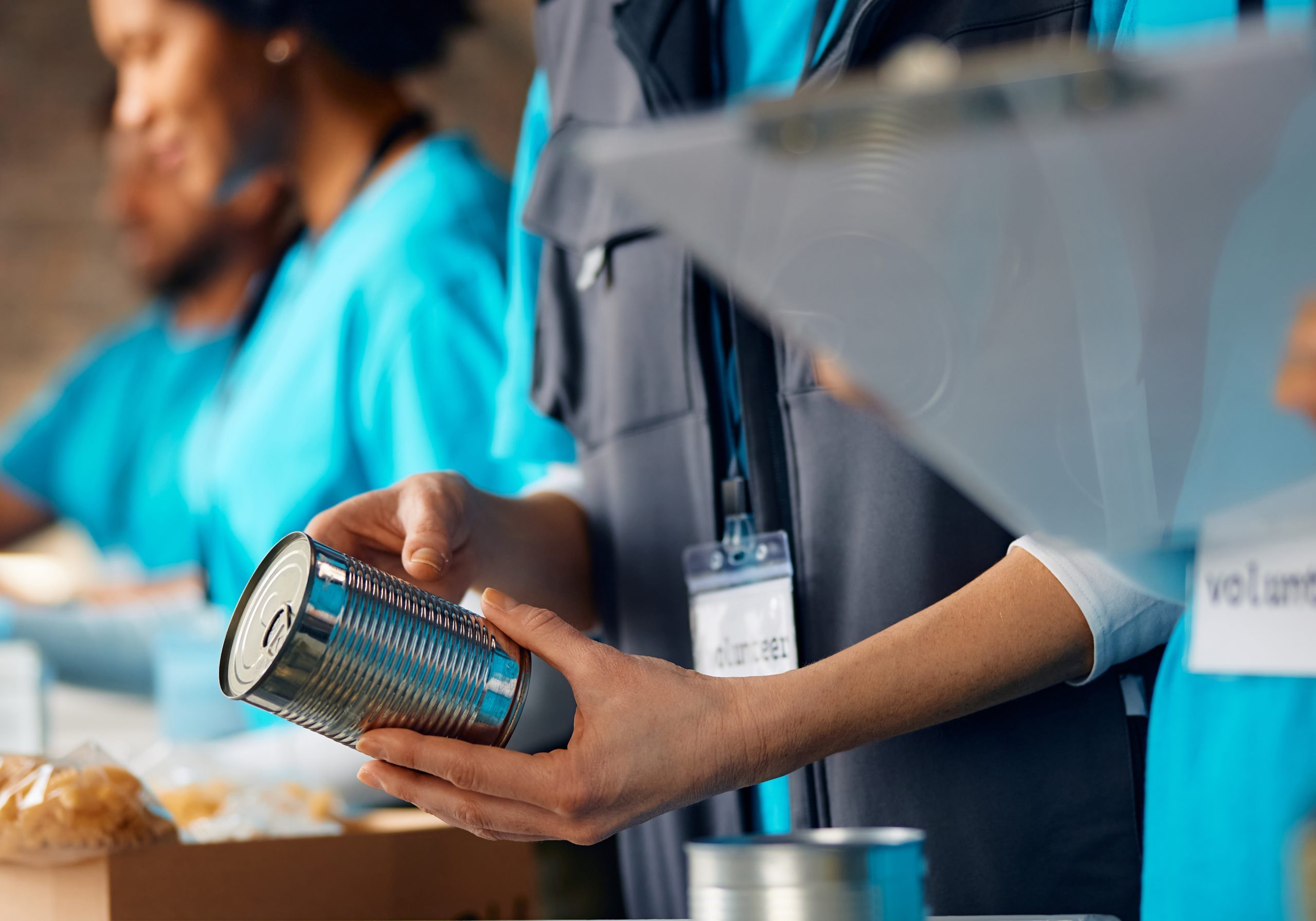 Close up of volunteers packing food at donation center.